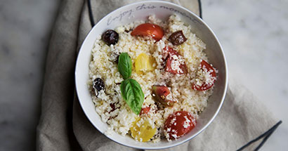 Skål med Middelhavs Blomkål Couscous opskrift med cherry tomater og oliven 